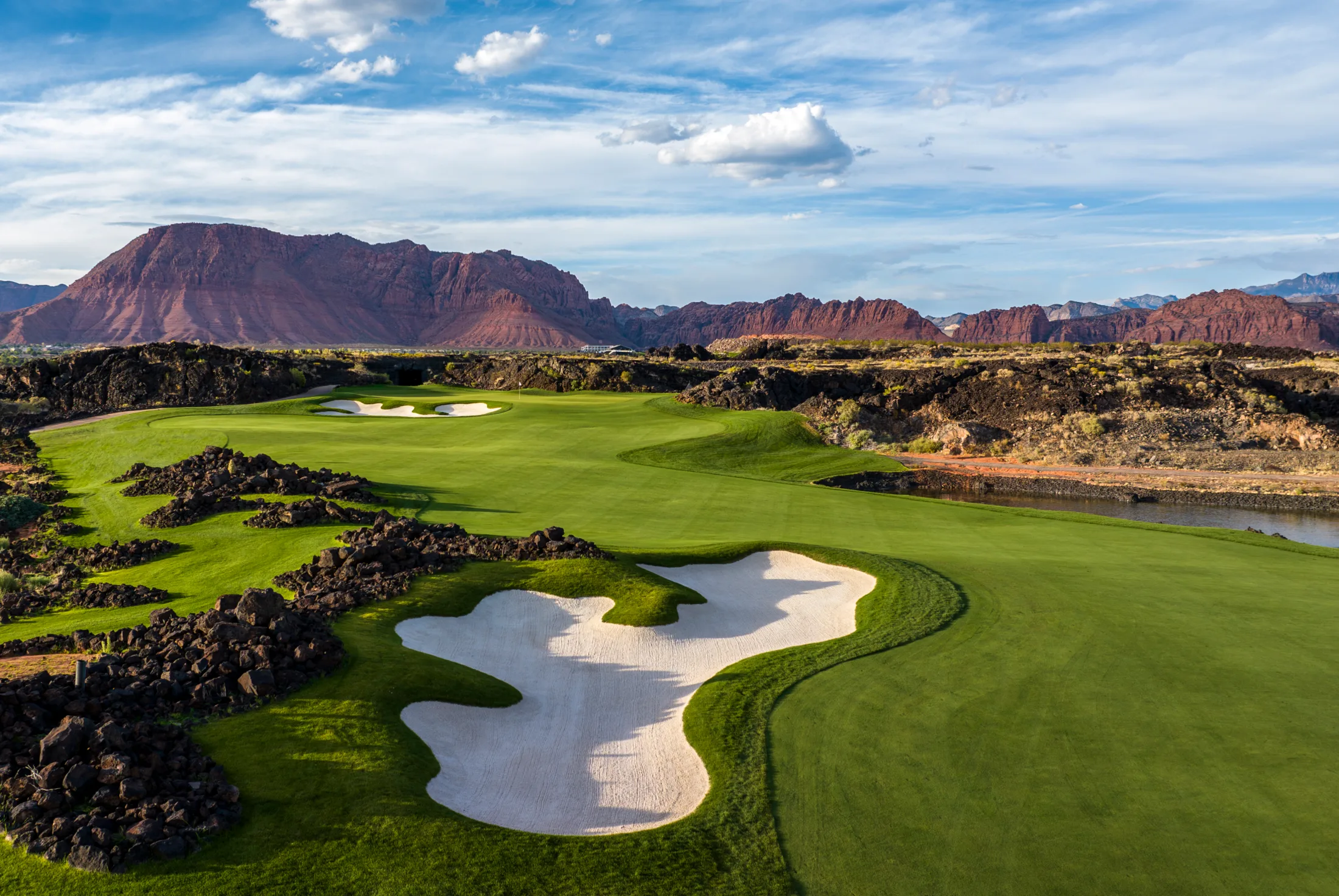 Golf course framed by red rock mountains